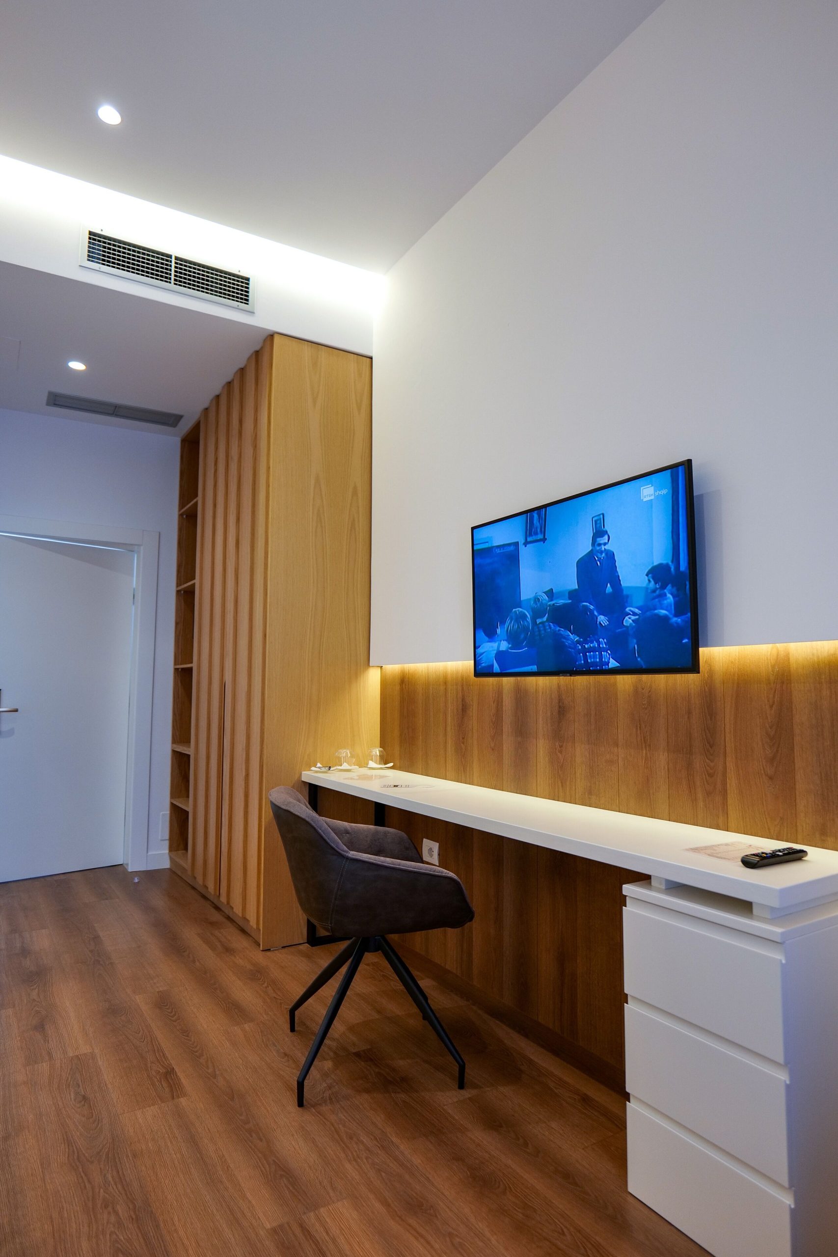 A wooden desk and television in the bedroom